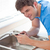 Assertive man repairing his sink in the kitchen at home stock photo © wavebreak_media