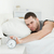 Man being awakened by an alarm clock in his bedroom stock photo © wavebreak_media