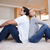 Side view of young couple sitting on the floor back-to-back stock photo © wavebreak_media