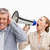 Businesswoman screaming with a megaphone after her colleague against white background stock photo © wavebreak_media