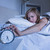 Woman in bed extending hand to alarm clock stock photo © wavebreak_media