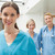 Smiling nurse with two nurse friends in hospital corridor stock photo © wavebreak_media