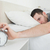 Sleeping attractive man being awakened by an alarm clock in his bedroom stock photo © wavebreak_media