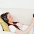 Attractive red-haired woman listening to music with headphones while lying on a sofa in the living r stock photo © wavebreak_media