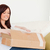 Attractive red-haired woman opening a carboard box while sitting on a sofa in the living room stock photo © wavebreak_media