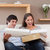 Young couple on the couch opening parcel stock photo © wavebreak_media