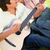 Man singing while playing the guitar as his friend leans on his shoulder while listening stock photo © wavebreak_media