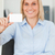 Smiling blonde businesswoman holding a card looks itno camera in her office stock photo © wavebreak_media