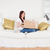 Attractive red-haired female opening a carboard box while sitting on a sofa in the living room stock photo © wavebreak_media
