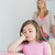 Little girl is sitting while looking exasperated at kitchen table wth mother in background stock photo © wavebreak_media